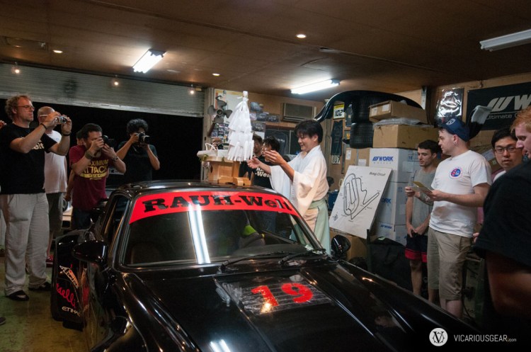As the vinyl was setting and the spray paint dried, a priest arrived to bless the race cars that would be competing in the event.