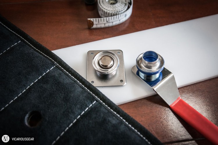 Pictured here are the dies that hold each half of the grommet. After placing the grommet through the hole, you give the upper die a few hits with a mallet...