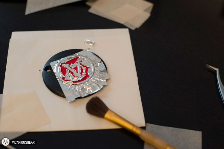 After painting on an adhesive (called "size") onto the areas where you want the foil to adhere, a super thin silver leaf is placed on top.